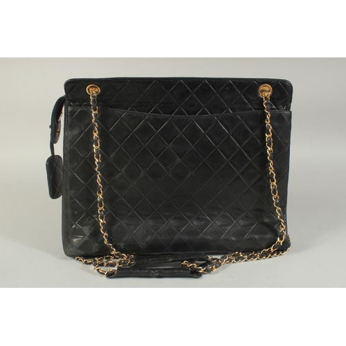 1335 - A LARGE CHANEL BLACK PADDED LEATHER BAG, 13ins long, 10ins high, with entwined gilt metal and leathe... 