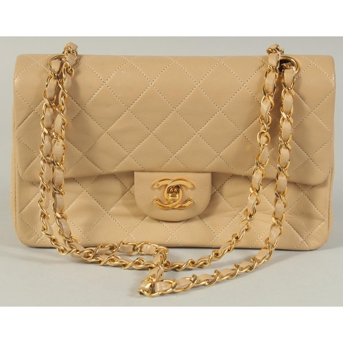 1343 - A CHANEL PADDED CREAM LEATHER HANDBAG with entwined leather and gilt strap, 9.5in wide.