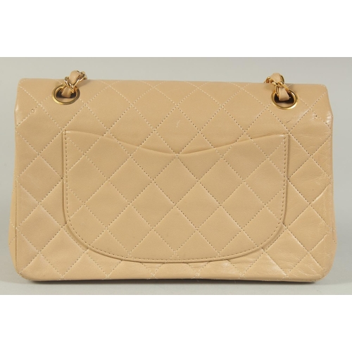 1343 - A CHANEL PADDED CREAM LEATHER HANDBAG with entwined leather and gilt strap, 9.5in wide.