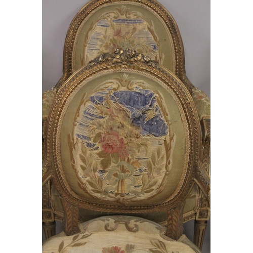 1016 - A GOOD SET OF FOUR LOUIS XVI 19TH CENTURY GILT ARMCHAIRS with oval backs and open arms, padded seats... 