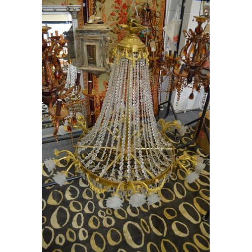 1026 - A BRASS AND CUT CRYSTAL CHANDELIER with scrolling branches having frosted glass shades.