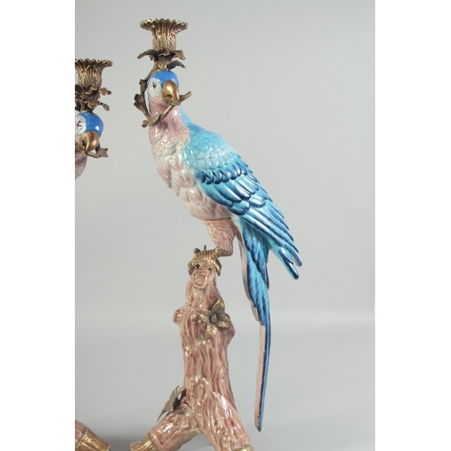 1121 - A GOOD PAIR OF BLUE PORCELAIN PARROT CANDLESTICKS on rustic bases, brass capped. 1ft 6ins high.