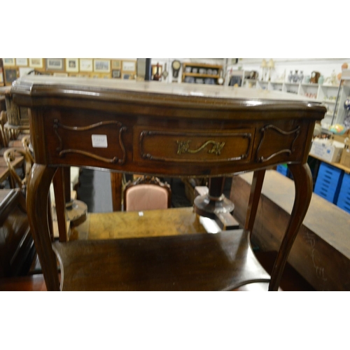 276 - A mahogany fold over card table of serpentine outline on cabriole legs united by an under tier.