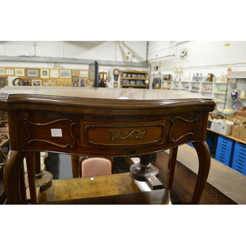 276 - A mahogany fold over card table of serpentine outline on cabriole legs united by an under tier.