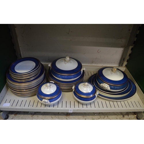 77 - A quantity of blue and gilt decorated dinner ware.