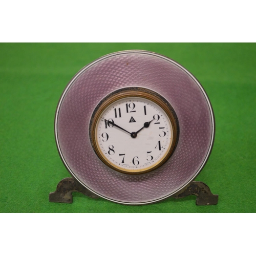 997 - A silver circular bedside clock with enamel decoration.