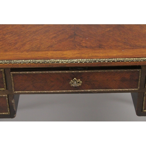 1027 - A LOUIS XVITH DESIGN WRITING TABLE with wooden top, five drawers on turned legs with ormolu mounts. ... 