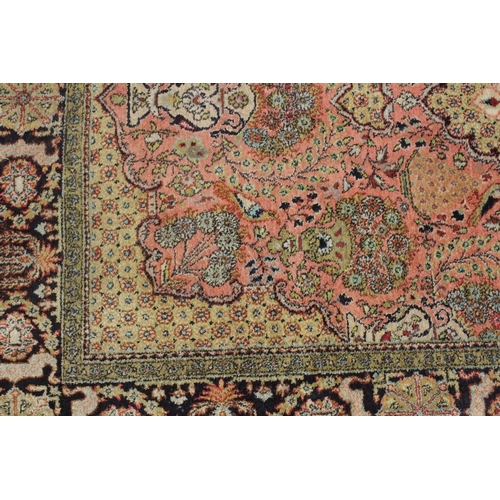 1040 - A PERSIAN PART SILK CARPET pink ground with sylised floral decoration within a similarly border. 210... 