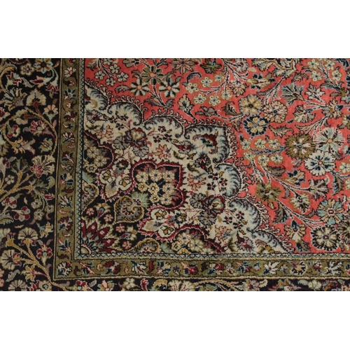 1041 - A PERSIAN PART SILK CARPET pink ground with sylised floral decoration within a similarly border. 210... 