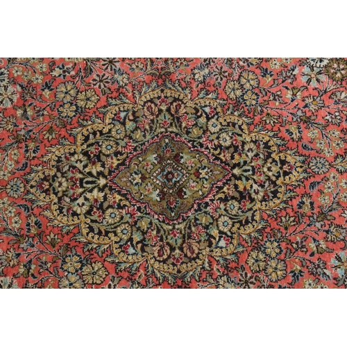 1041 - A PERSIAN PART SILK CARPET pink ground with sylised floral decoration within a similarly border. 210... 