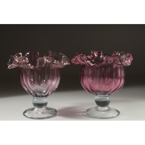 1054 - A PAIR OF CRANBERRY CIRCULAR BOWLS. 7.5ins high.