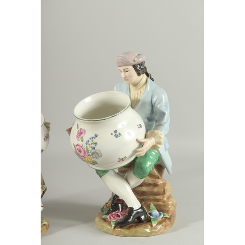 1083 - A PAIR OF SEVRES DESIGN PORCELAIN FIGURES OF A MAN AND WOMAN HOLDING BOWLS, the bases with flowers. ... 