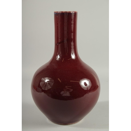 102 - A LARGE CHINESE OX BLOOD GLAZE PORCELAIN VASE, the base with six-character mark, 33.5cm high.