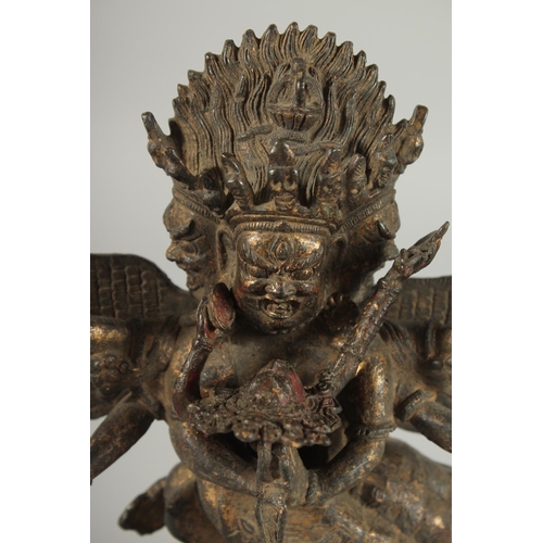 107 - A TIBETAN BRONZE FIGURE OF A THREE-HEADED DEITY, 24.5cm high.