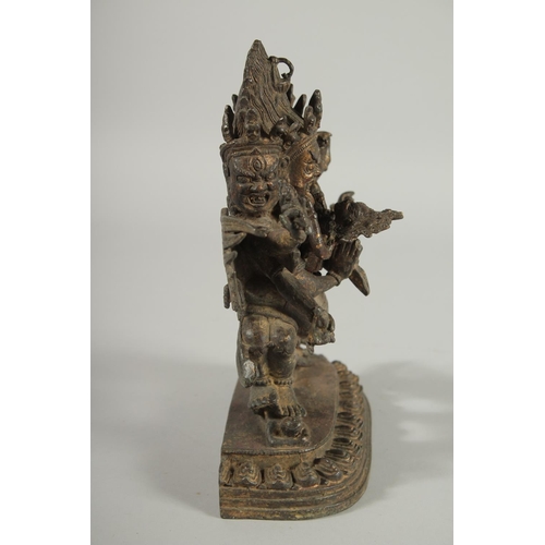 107 - A TIBETAN BRONZE FIGURE OF A THREE-HEADED DEITY, 24.5cm high.