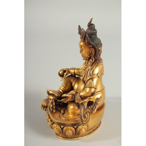 108 - A TIBETAN GILT ALLOY FIGURE OF A SEATED DEITY, 15cm high.