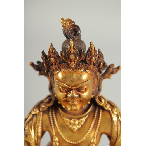 108 - A TIBETAN GILT ALLOY FIGURE OF A SEATED DEITY, 15cm high.