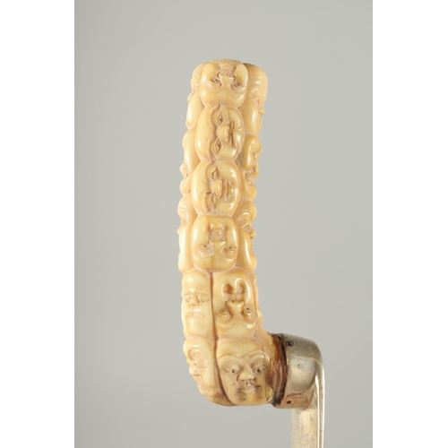 119 - A SILVER PAGE TURNER WITH CARVED BONE HANDLE, the handle carved as multiple masks, page turner with ... 