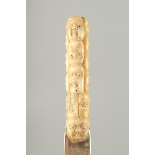 119 - A SILVER PAGE TURNER WITH CARVED BONE HANDLE, the handle carved as multiple masks, page turner with ... 