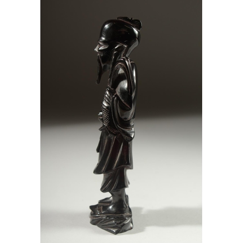 149 - A CHINESE BAKELITE FIGURE on a fitted wooden stand, figure 15cm high.