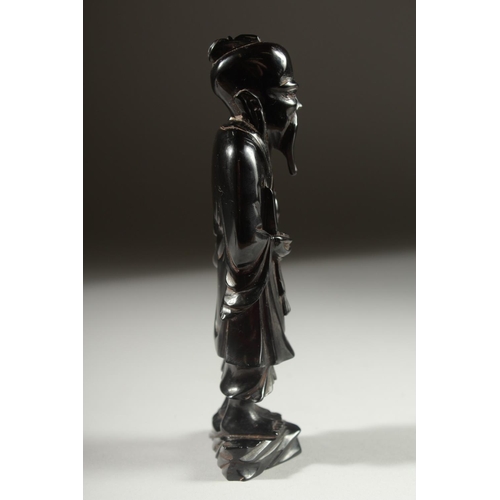 149 - A CHINESE BAKELITE FIGURE on a fitted wooden stand, figure 15cm high.