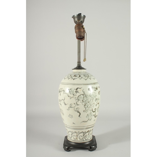 168 - A CHINESE PORCELAIN VASE LAMP, mounted to a hardwood base, decorated with grapes, 55cm high overall.