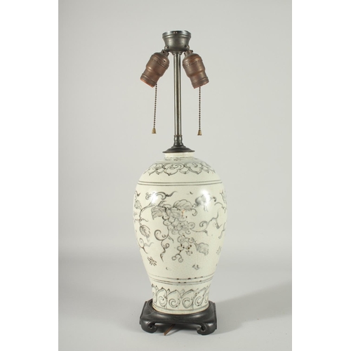 168 - A CHINESE PORCELAIN VASE LAMP, mounted to a hardwood base, decorated with grapes, 55cm high overall.