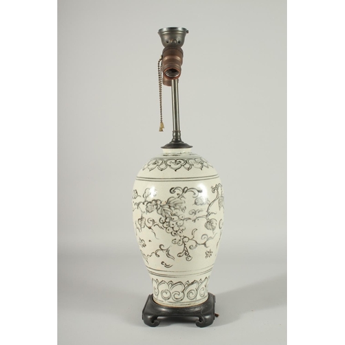 168 - A CHINESE PORCELAIN VASE LAMP, mounted to a hardwood base, decorated with grapes, 55cm high overall.