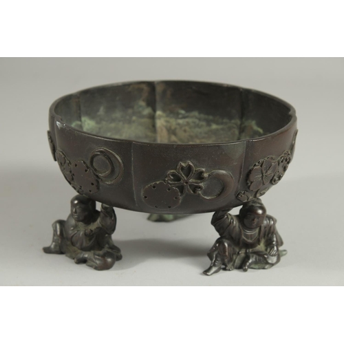 177 - A JAPANESE BRONZE PETAL FORM BOWL, raised on three mounted figural feet, the bowl with relief mon de... 