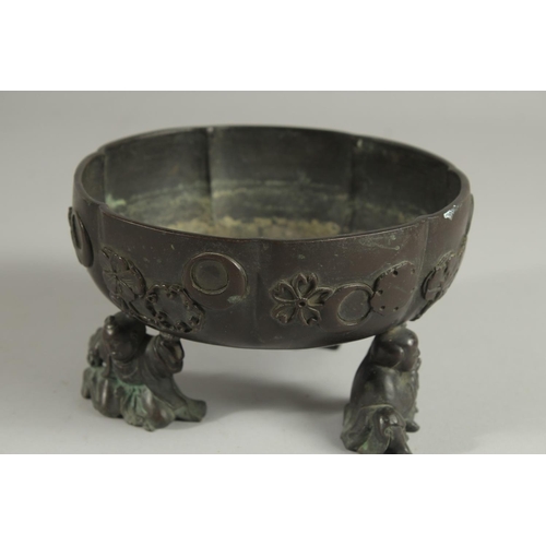 177 - A JAPANESE BRONZE PETAL FORM BOWL, raised on three mounted figural feet, the bowl with relief mon de... 