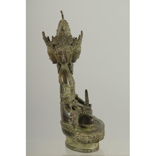 179 - A FIGURE OF A SEATED MULTI-HEADED DEITY, 22cm high.