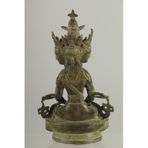 179 - A FIGURE OF A SEATED MULTI-HEADED DEITY, 22cm high.