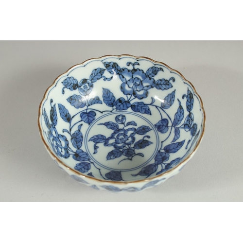 18 - A CHINESE BLUE AND WHITE PORCELAIN BOWL, with ribbed exterior and petal form rim, decorated with flo... 