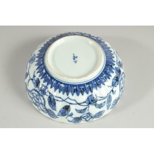 18 - A CHINESE BLUE AND WHITE PORCELAIN BOWL, with ribbed exterior and petal form rim, decorated with flo... 