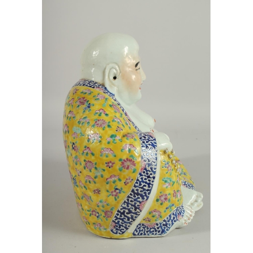 182 - A LARGE CHINESE FAMILLE JAUNE PORCELAIN LAUGHING BUDDHA, the deity modelled in the seated position h... 