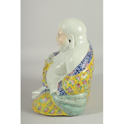 182 - A LARGE CHINESE FAMILLE JAUNE PORCELAIN LAUGHING BUDDHA, the deity modelled in the seated position h... 