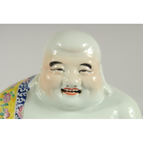 182 - A LARGE CHINESE FAMILLE JAUNE PORCELAIN LAUGHING BUDDHA, the deity modelled in the seated position h... 