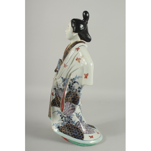 183 - A FINE AND LARGE JAPANESE ARITA PORCELAIN BIJIN, the robe painted with blue and white patterns and r... 