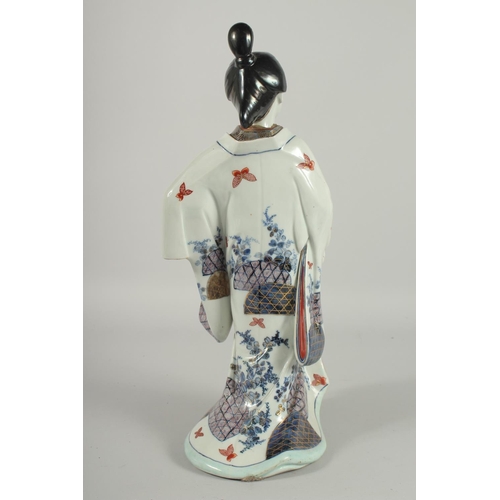 183 - A FINE AND LARGE JAPANESE ARITA PORCELAIN BIJIN, the robe painted with blue and white patterns and r... 