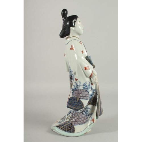 183 - A FINE AND LARGE JAPANESE ARITA PORCELAIN BIJIN, the robe painted with blue and white patterns and r... 