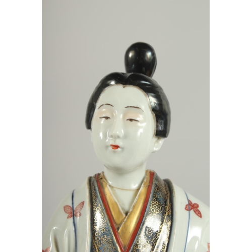 183 - A FINE AND LARGE JAPANESE ARITA PORCELAIN BIJIN, the robe painted with blue and white patterns and r... 