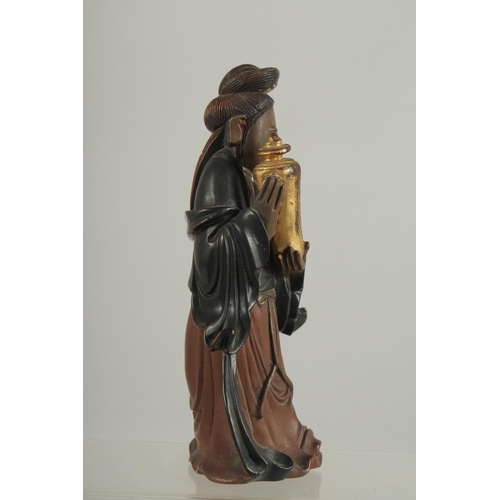 189 - A LACQUERED AND GILDED CARVED WOODEN  FIGURE, of Guanyin holding an urn, 17cm high.