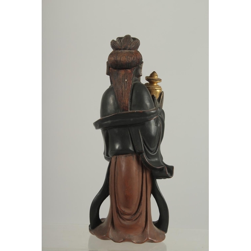 189 - A LACQUERED AND GILDED CARVED WOODEN  FIGURE, of Guanyin holding an urn, 17cm high.