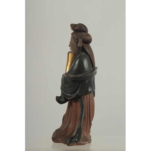 189 - A LACQUERED AND GILDED CARVED WOODEN  FIGURE, of Guanyin holding an urn, 17cm high.