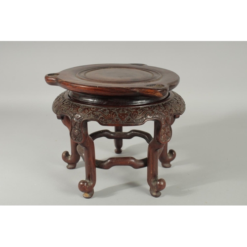 191 - A LARGE CHINESE CARVED HARDWOOD STAND, with circular top, the skirt carved with bat motifs, elevated... 