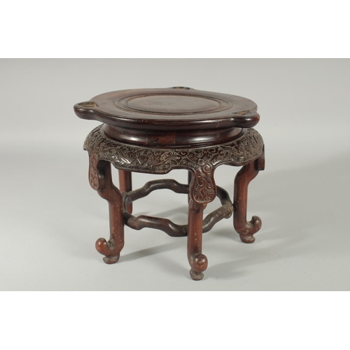 191 - A LARGE CHINESE CARVED HARDWOOD STAND, with circular top, the skirt carved with bat motifs, elevated... 