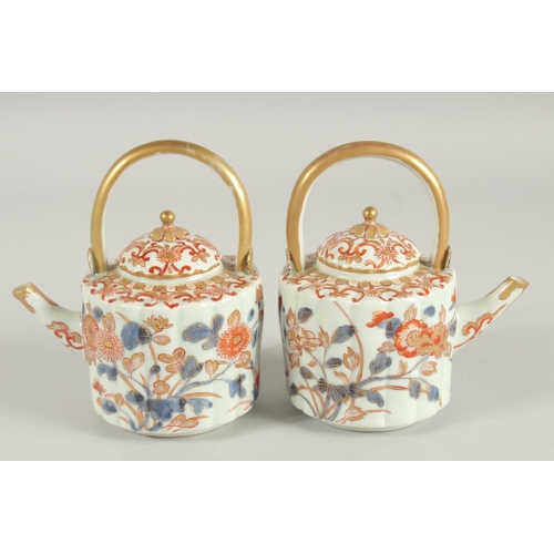 197 - A FINE PAIR OF IMARI PORCELAIN TEAPOTS, painted in the typical Imari palette with blue, red and gilt... 