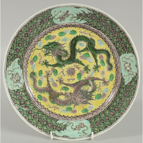 2 - A CHINESE FAMILLE VERTE PORCELAIN PLATE, finely painted with two dragons and stylised clouds on a ye... 