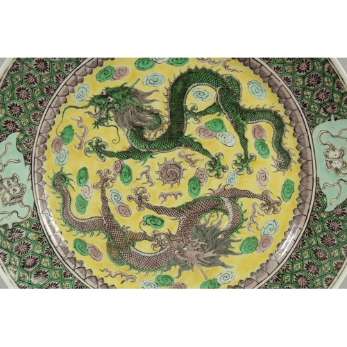 2 - A CHINESE FAMILLE VERTE PORCELAIN PLATE, finely painted with two dragons and stylised clouds on a ye... 