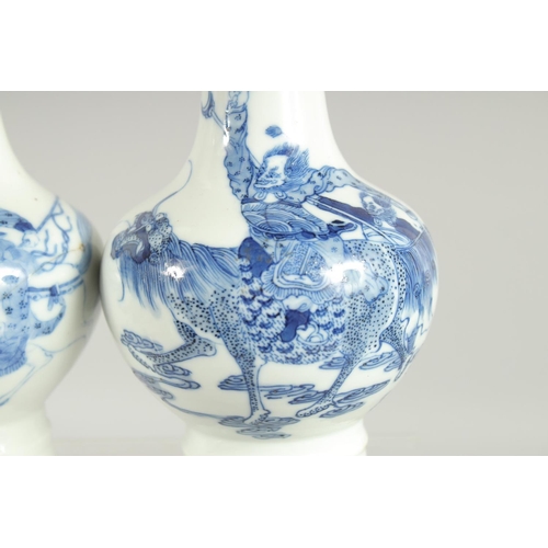 200 - A FINE PAIR OF CHINESE BLUE AND WHITE PORCELAIN BOTTLE VASES, one painted with a warrior riding a be... 